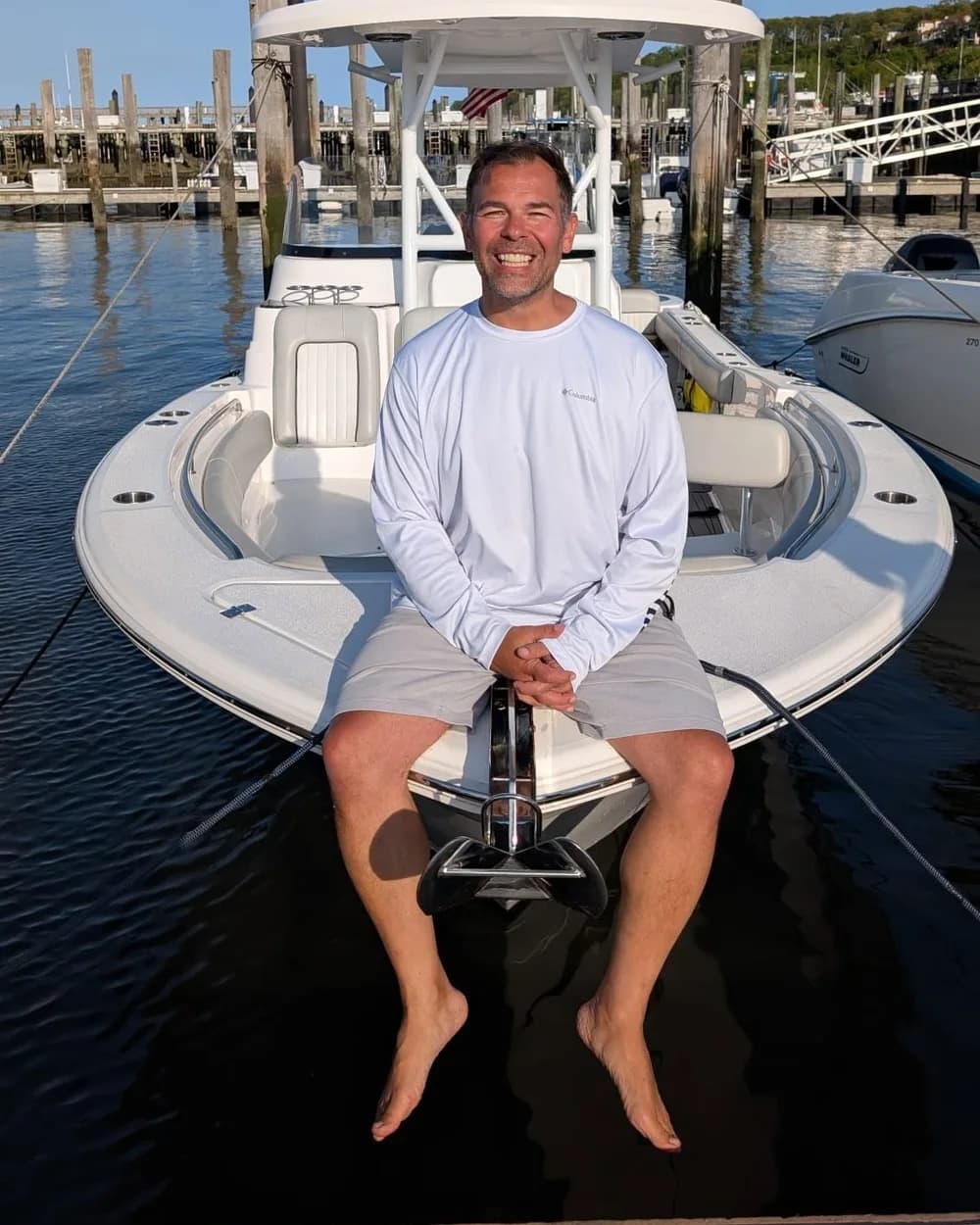 Michael A. Ramos, founder and president of BoatLife Foundation, sitting on the bow of a center console boat at a New Jersey marina
